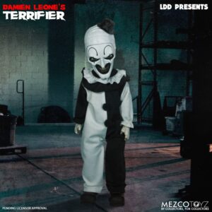 Mezco Toyz presenta, dentro de la colección Living Dead Dolls, la figura de Art The Clown. Mide 27 cm y está basada en el personaje de la película "Terrifier". Luce su característico traje de payaso blanco y negro con pompones y volantes. Incluye 1x cuchillo de carnicero. Viene en una caja con ventana.