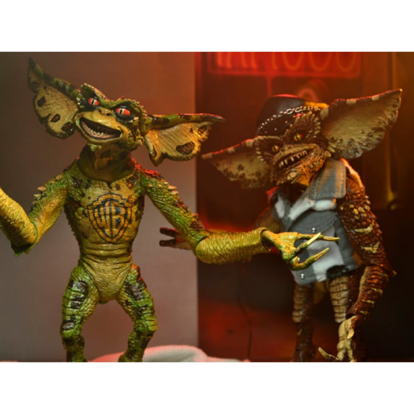 Neca presenta este set de 2 figuras de Gremlins en el éstos asaltan un salón de tatuajes. Esta escena se basa en la divertidísima secuela de Warner Bros, "Gremlins 2: La nueva generación". Cada figura mide unos 18 cms e incluye manos intercambiables, una máquina para hacer tatuajes, un mazo, unas gafas de sol, una fusta, una toalla de tela y un chaleco tejano.