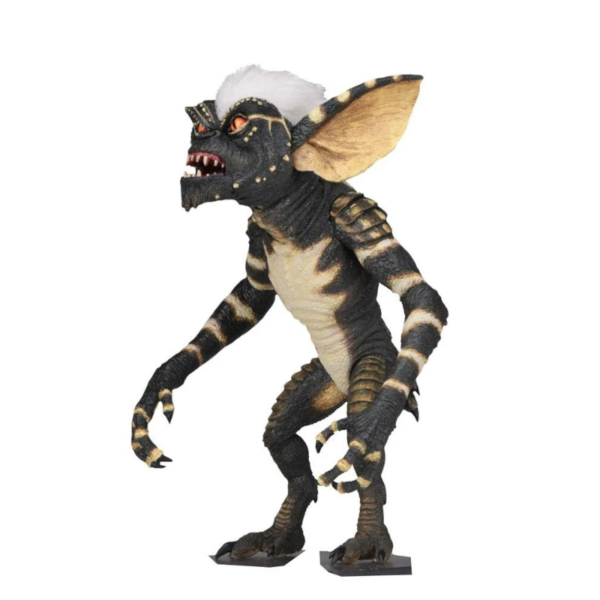 NECA presenta la versión Ultimate de Stripe, basada en la película original de 1984 "Gremlins" y anunciada en la San Diego Comic Con 2018. Todo fan sabe que tiene que proteger al Mogwai de la luz solar, que no puede mojarlo y que no puede darle de comer pasada la medianoche. Si sigue estas reglas, disfrutará de un lindo y amistoso Mogwai... Si falla, se enfrentará a algunos personajes bastante peligrosos, como Stripe, el líder de los malvados Gremlins. Esta figura es una versión articulada con más de 25 puntos de articulación, incluidas las orejas y la mandíbula, hecha en PVC y con un tamaño de unos 18 cm. Incluye además una motosierra, un monopatín con ruedas giratorias, hoja de sierra y manos intercambiables